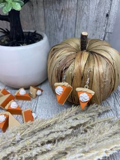 an orange and white pumpkin sitting on top of a wooden table next to other decorations