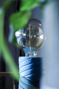 a light bulb sitting on top of a blue vase