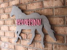 a sign on the side of a brick wall that says brooklyn, with a horse