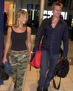 a man and woman walking through an airport