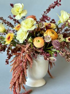 a white vase filled with lots of flowers