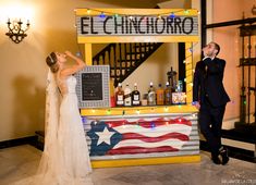 a bride and groom standing in front of an american flag bar