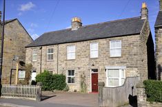 an old stone house with a red door