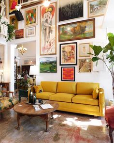 a living room filled with furniture and pictures on the wall