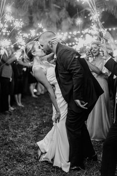 a bride and groom kissing while surrounded by sparklers