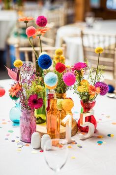 colorful flowers in vases on a table with confetti