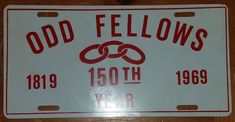 a white license plate with red lettering on it that reads odd fellows, 1950 year