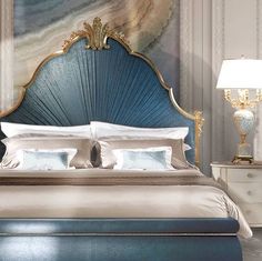 a bedroom with a large blue bed and white pillows on top of it's headboard