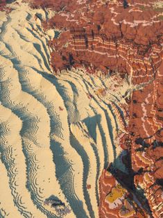 an aerial view of sand dunes and cliffs in the desert, looking down on them