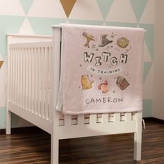 a white crib with a baby's name written on it in front of a wall