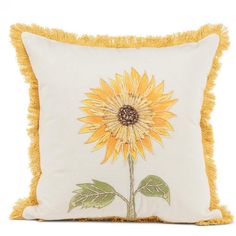 a yellow and white pillow with a sunflower on it