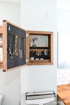 an open cabinet with jewelry hanging on the wall