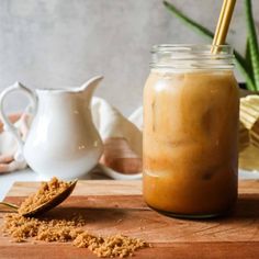 a jar filled with food sitting on top of a wooden cutting board next to a spoon