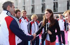 a man shaking hands with a woman in front of other people on a tennis court