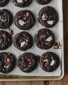 chocolate cookies and marshmallows are arranged on a baking sheet, ready to be eaten