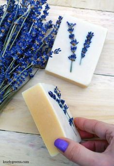 soap bar with lavender flowers on it and someone's hand next to the bars