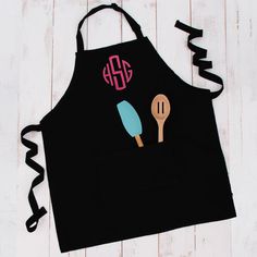 a black apron with two ice cream scoops and a monogrammed spoon on it