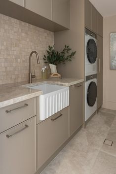 a kitchen with a sink, washer and dryer next to each other in it