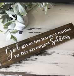 a wooden sign that says god gives his hardest battles to his strongest soldiers on it