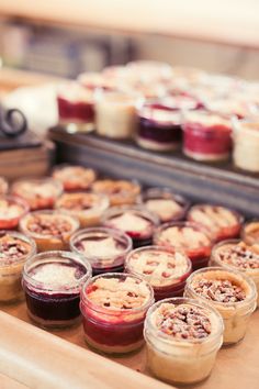 many desserts are in small glass containers on a table