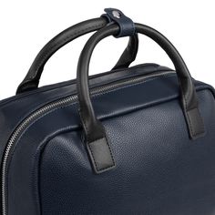 a blue leather briefcase with black handles