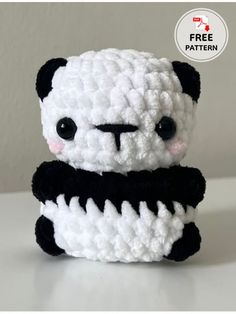 a crocheted panda bear sitting on top of a table