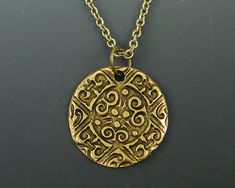 Men's coin necklace features an ancient style ornate antique gold pendant. Your choice of chain lengths - 18, 20, 24, 30 Pendant is made of antique gold plated pewter and is 15/16 inches in diameter (24mm). Find more men's jewelry styles here - https://www.etsy.com/shop/CharleneSevier?ref=hdr_shop_menu&section_id=10866473 Ancient Style Gold Brass Jewelry, Bronze Coin Pendant Necklace, Symbolic Brass Coin Necklace With Round Pendant, Symbolic Brass Medallion Coin Necklace, Bronze Medallion Necklace With Coin Pendant, Antique Gold Medallion Amulet Necklace, Gold Ancient Style Engraved Necklace, Bronze Brass Coin Necklace With Round Pendant, Antique Gold Coin Necklace Nickel Free