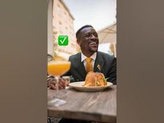 a man in a suit and tie sitting at a table with two plates of food