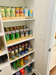 an organized pantry with lots of food items on the shelves, including canned and canned foods