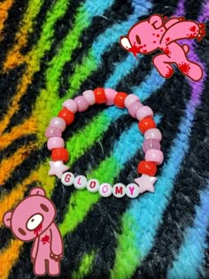 a pink teddy bear bracelet with the word gummy on it next to an image of a stuffed animal