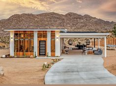 a house in the desert with mountains in the backgrouds and an open patio area