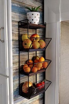 three metal baskets filled with fruit sitting on top of a wall