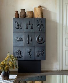 a shelf with vases and other decorative items on it in a room that has white walls