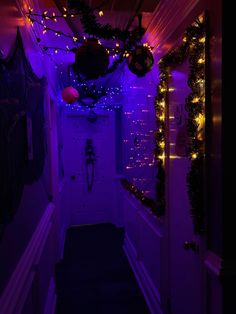 the hallway is lit up with purple lights and garlands on the wall above it