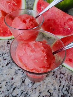 two glasses filled with ice cream next to slices of watermelon