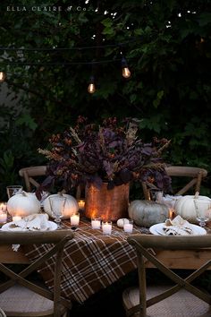 the table is set with pumpkins and candles