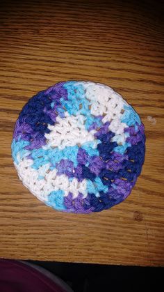 a crocheted blue and white dishcloth on a wooden table