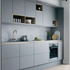 a kitchen with gray cabinets and white counter tops