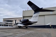 an airplane is parked in front of a hangar