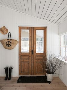 a wooden door sitting inside of a white house