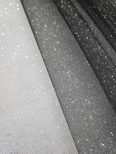 black and white sheer fabric with silver glitters on the edges, closeup view