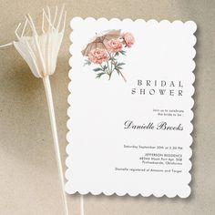 a bridal shower card with pink flowers on it next to a flower pinwheel