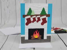 a card with a fireplace and stockings on it