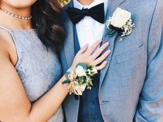 a man and woman wearing boutonnieres standing next to each other