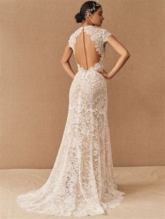 the back of a woman's wedding dress with an open back and lace detailing