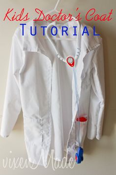 a white shirt hanging on a wall with the words kids doctor's coat over it