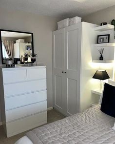 a bedroom with a bed, dresser and mirror