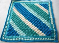 a blue and white crocheted blanket sitting on top of a table