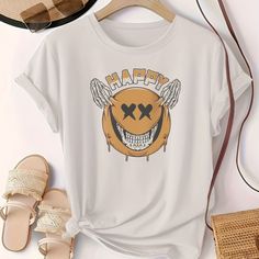 a t - shirt with the words happy on it next to sandals and a purse