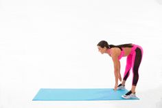 a woman in pink shirt and black leggings doing push up on blue mat